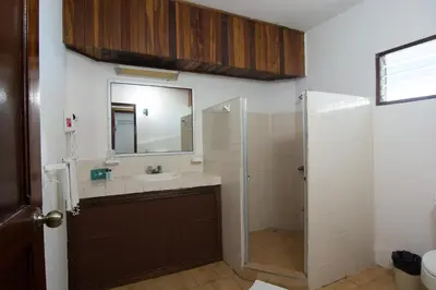 a bathroom with a sink and a shower with a mirror at Beach Break Resort & CR Surf Camp in Jacó