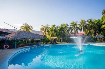 a fountain in the middle of a swimming pool at Beach Break Resort & CR Surf Camp in Jacó