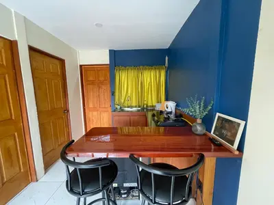 a kitchen with a counter and two black chairs at Apartamento Nuevo amueblado La Paz #1 Quepos in Savegre