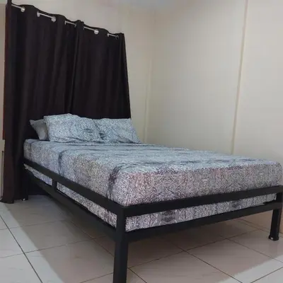 a bed in a room with a black curtain at Apartamento Nuevo amueblado La Paz #1 Quepos in Savegre