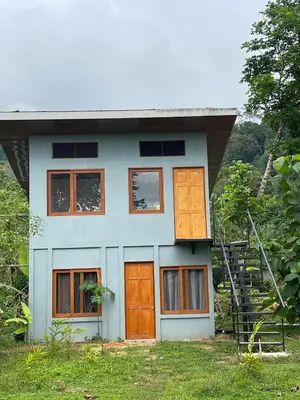 a small house with orange doors and a staircase at Apartamento Nuevo amueblado La Paz #1 Quepos in Savegre