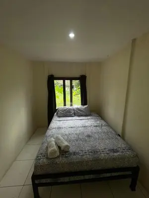 a bed in a room with two shoes on it at Apartamento Nuevo amueblado La Paz #1 Quepos in Savegre