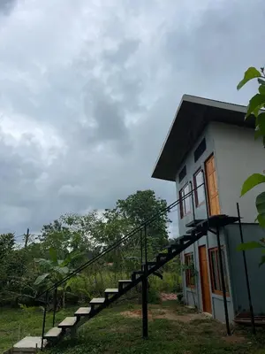 a house with a staircase leading up to it at Apartamento Nuevo amueblado La Paz #1 Quepos in Savegre