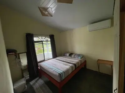 a small bedroom with a bed and a window at Peace Home in Quepos near Beaches & Mountains in Savegre