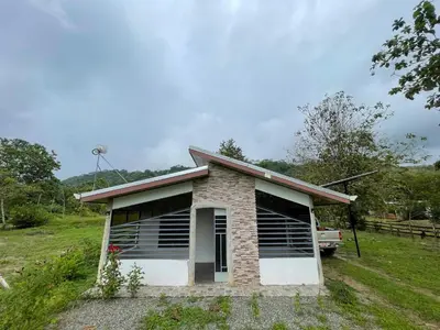 a small house in a field with a truck at Peace Home in Quepos near Beaches & Mountains in Savegre