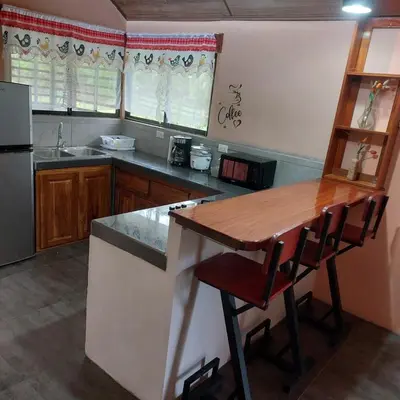 a kitchen with a counter and a wooden counter top at Peace Home in Quepos near Beaches & Mountains in Savegre