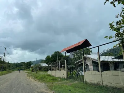 a person walking down a dirt road next to a building at Peace Home in Quepos near Beaches & Mountains in Savegre