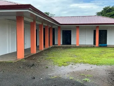 a building with orange and white columns and a yard at Casa playa vacaciones in Santa Cruz