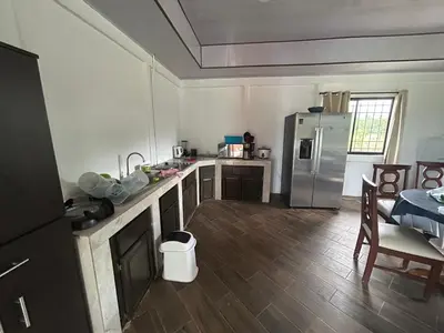a kitchen with a stainless steel refrigerator and wooden floors at Casa playa vacaciones in Santa Cruz