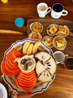 a plate of food on top of a wooden table at Artistic house in a coffee plantation in Tajo Alto