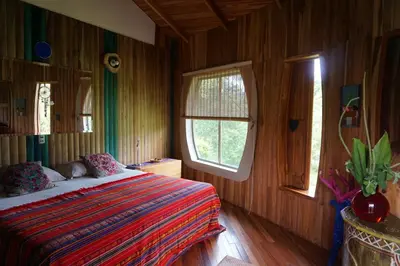 a bedroom with a bed and a window in it at Artistic house in a coffee plantation in Tajo Alto