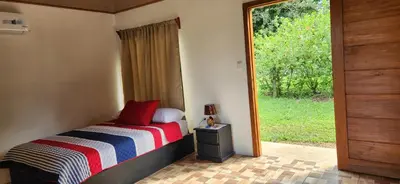 a bedroom with a bed and a door with a window at Rios-lodge in Mirador