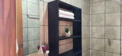a bathroom with a shelf with towels and a plant at Rios-lodge in Mirador