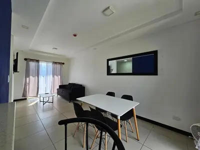 a living room with a table and chairs and a tv at Apartamento Boulevar Park in Heredia