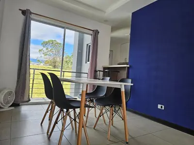 a table and chairs in a kitchen with a large window at Apartamento Boulevar Park in Heredia