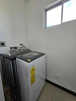 a small washing machine in a room with a window at Apartamento Boulevar Park in Heredia