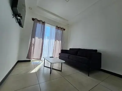 a living room with a black couch and a table at Apartamento Boulevar Park in Heredia