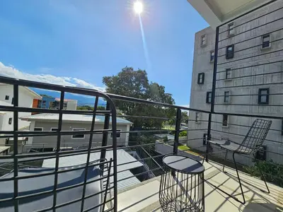a balcony with two chairs and a building at Apartamento Boulevar Park in Heredia