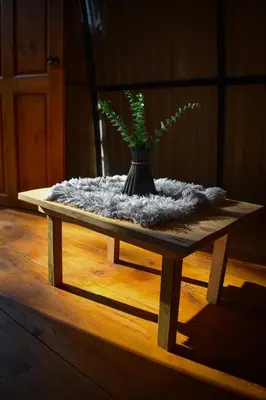 a wooden table with a vase with a plant on it at Cabaña el Chapuzón montaña y rio, lugar fresco in Cedral