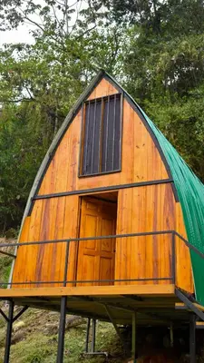 a small wooden house with a green roof at Cabaña el Chapuzón montaña y rio, lugar fresco in Cedral