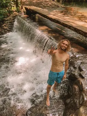 a man standing in front of a waterfall at Hotel del Bosque in Río Cuarto