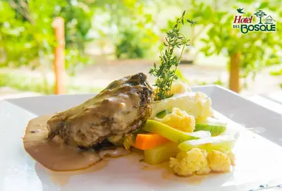 a plate of food with meat and vegetables on a table at Hotel del Bosque in Río Cuarto