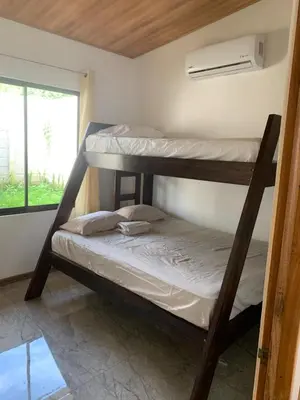 two bunk beds in a room with a window at Casas Vacacionales Tambor Beach in Puntarenas