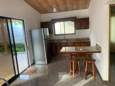 a kitchen with a table and a refrigerator at Casas Vacacionales Tambor Beach in Puntarenas