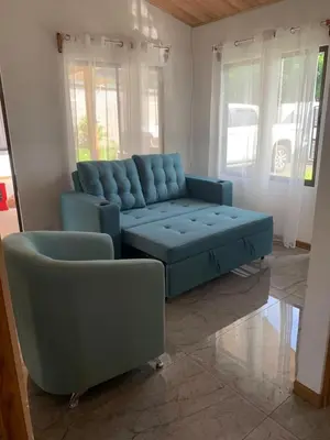 a living room with a blue couch and a table at Casas Vacacionales Tambor Beach in Puntarenas