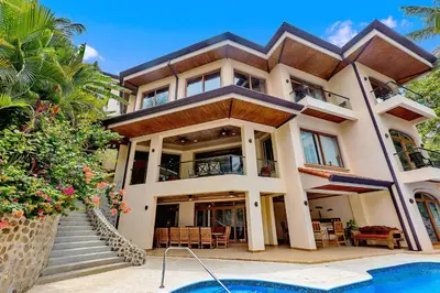 a large house with a pool in front of it at Ocean Front Palacio Tropical in Puntarenas