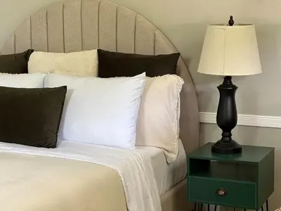 a bed with a lamp on a green night stand at Apartamento Chic en la Montaña AC in Turrialba