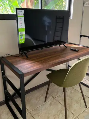a computer monitor sitting on a desk with a chair at Apartamento Chic en la Montaña AC in Turrialba