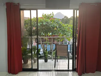 an open door to a balcony with plants at Villa JADE, La Fortuna Downtown Apartment in Fortuna