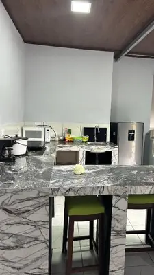 a large kitchen with a counter with stools in it at Villa JADE, La Fortuna Downtown Apartment in Fortuna