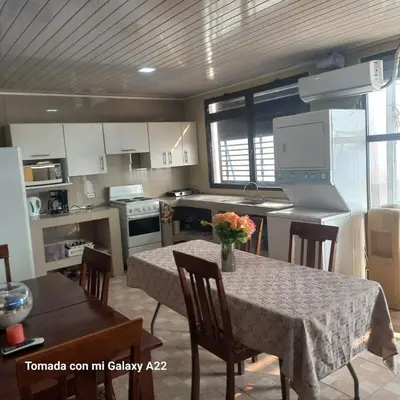 a kitchen with a table and chairs and a kitchen with white cabinets at Ocean-View Maryland House in Esparza