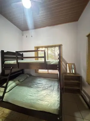 two bunk beds in a room with a window at Casa Mangos Macondo Lepanto in Lepanto
