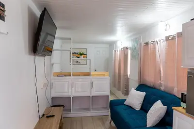 a living room with a blue couch and a tv at Nido del Parque, Zarcero in Zarcero