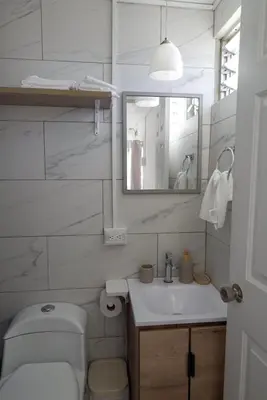 a bathroom with a toilet and a sink and a mirror at Nido del Parque, Zarcero in Zarcero