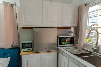 a kitchen with white cabinets and a microwave on a counter at Nido del Parque, Zarcero in Zarcero
