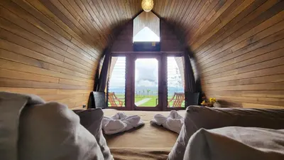 a room with a large window in a wooden wall at Arenal 360 Lodge in Fortuna