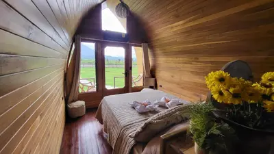 a bedroom with a bed with flowers and a window at Arenal 360 Lodge in Fortuna