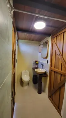 a small bathroom with a toilet and a sink at Arenal 360 Lodge in Fortuna