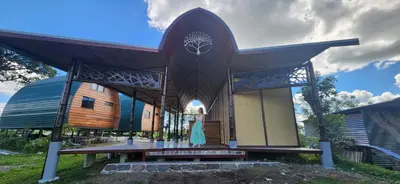 a large wooden building with a bench in front of it at Arenal 360 Lodge in Fortuna