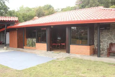 a house with a red roof and a patio at Posada de Leda y Jose in Turrialba