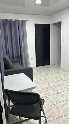 a living room with a table and a couch at Alojamiento Coral in Quepos