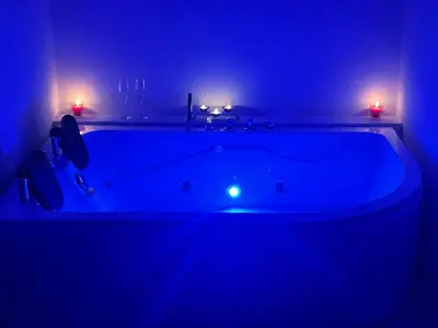 a blue bath tub in a bathroom with two candles at Alojamiento Coral in Quepos