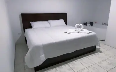 a bedroom with a bed and a bath tub at Alojamiento Coral in Quepos