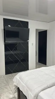 a bedroom with a bed and a black wall at Alojamiento Coral in Quepos