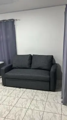 a couch sitting in a living room next to a wall at Alojamiento Coral in Quepos
