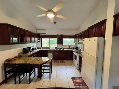 a kitchen with a table and a white refrigerator at Serena Suites H3 in Coco